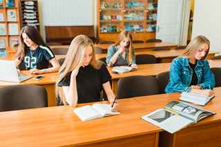 Medical student studying with books and laptop