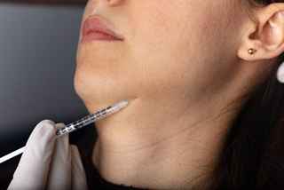 Injection to the face in the chin area. aesthetics, medicine concept. youth injections.